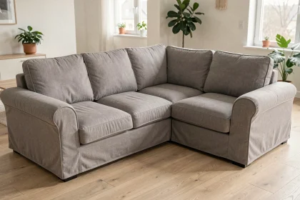 Protège canapé d'angle en lin gris installé sur un canapé modulable dans un salon scandinave moderne